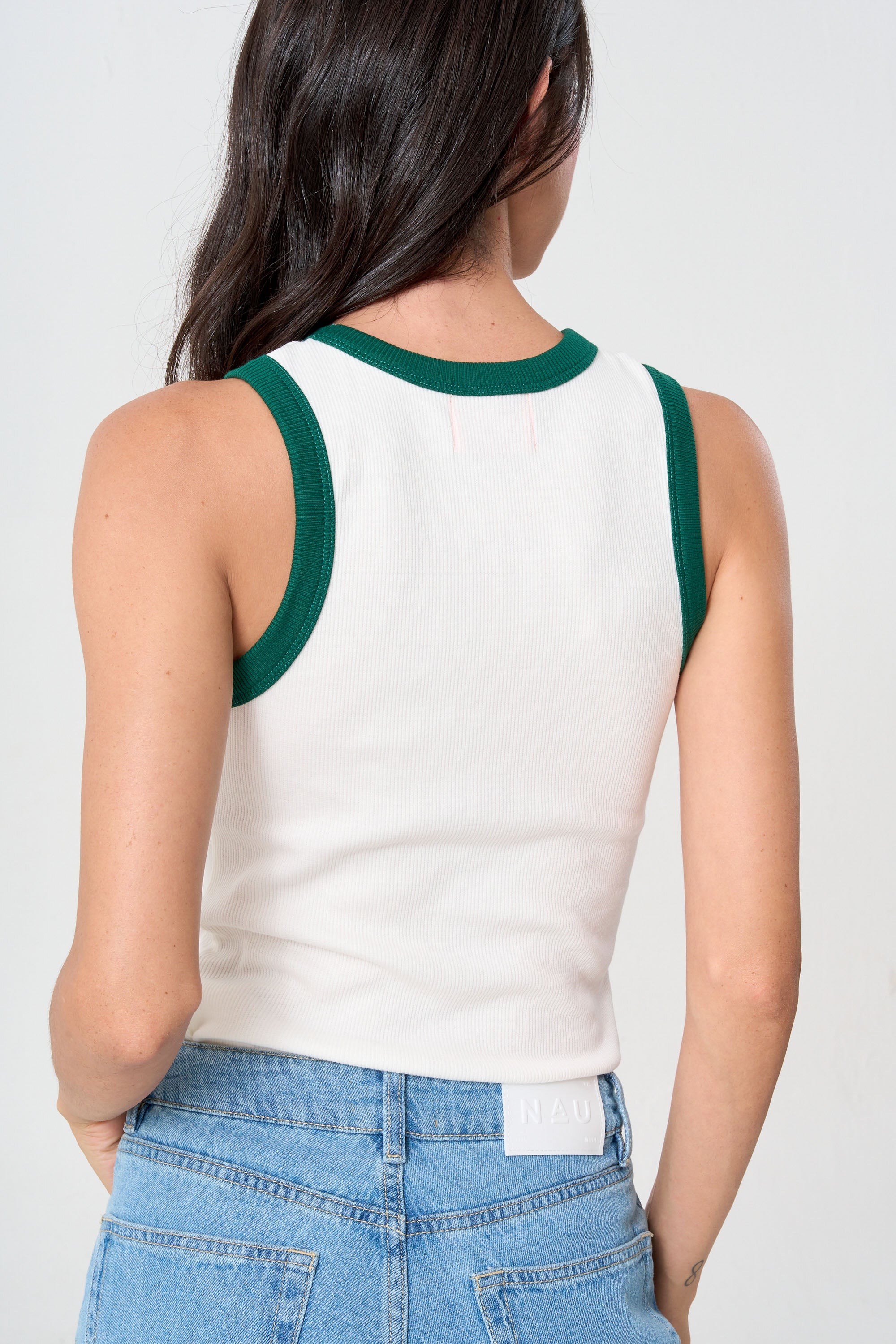 Tank top deportivo para mujer en tela elástica y transpirable.
