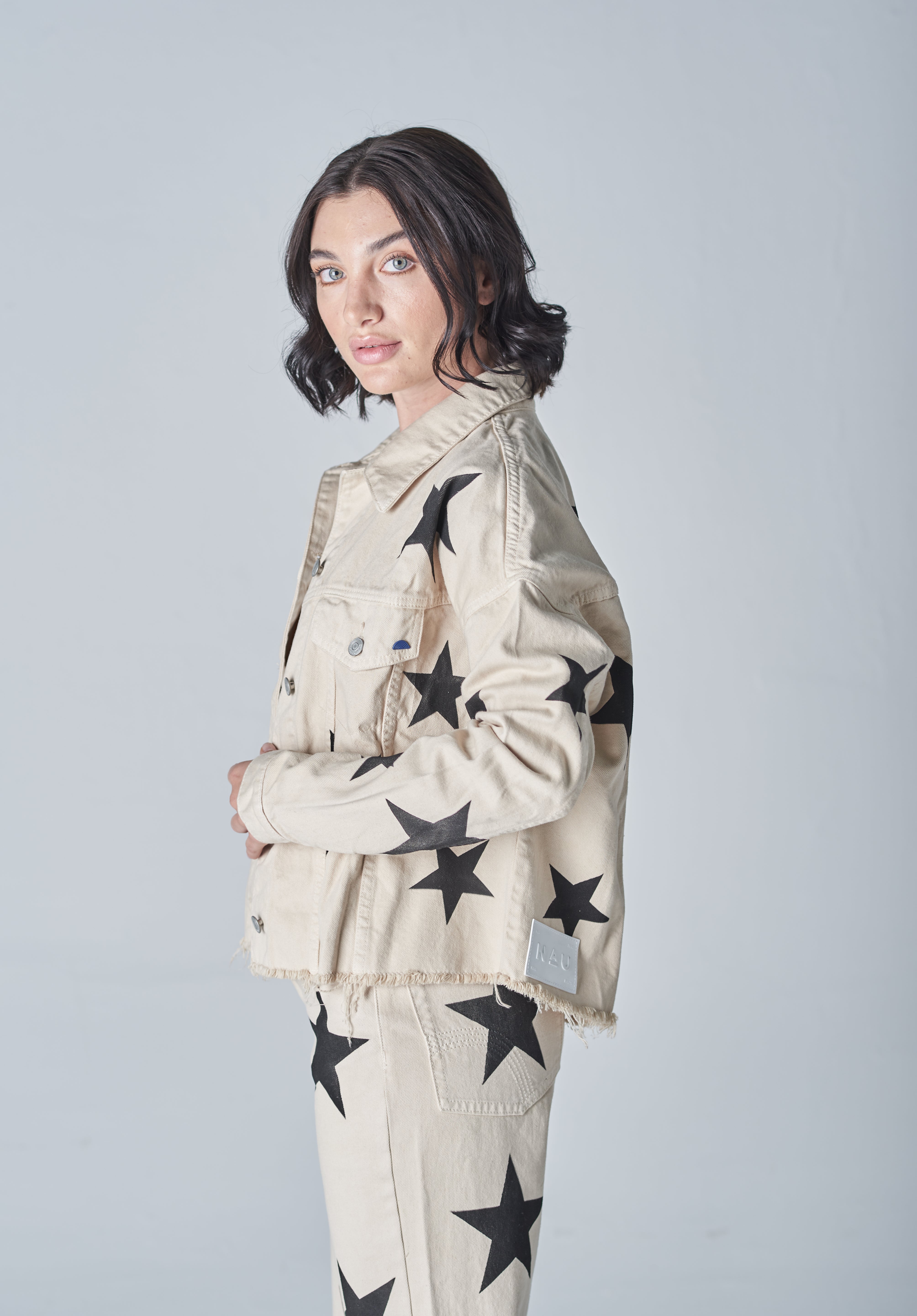 Chaqueta de mezclilla beige para mujer estilo casual y con diseño desgastado.
